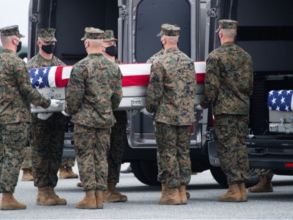 A flag-draped transfer case with the remains of a fallen service member are placed inside